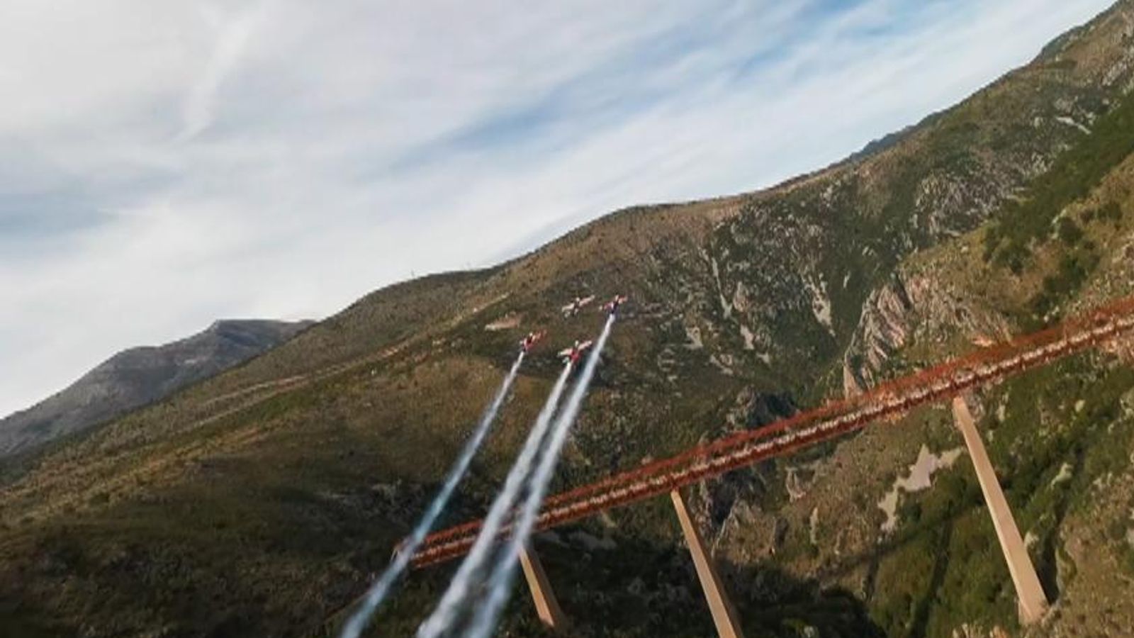 Czech stunt pilots perform upside down loop in formation around viaduct