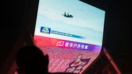 News footage of the drills on a screen in Beijing. Pic: Reuters