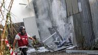 An Israeli firefighter works to put out a fire after a projectile landed at the scene in Kfar Chabad. Pic: Reuters