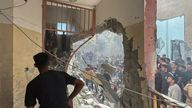 Palestinians inspect the site of an Israeli strike on a school sheltering displaced people in Nuseirat.
Pic: Reuters