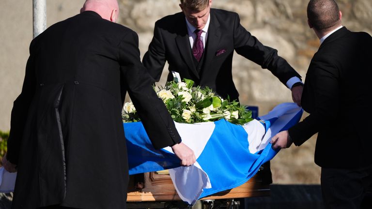 Pall bearers drape a Saltire flag over the coffin as it arrives at the funeral service for former first minister of Scotland Alex Salmond, at Strichen Parish Church in Strichen, Fraserburgh. The former Alba Party and SNP leader died of a heart attack while attending a conference in North Macedonia earlier this month. Picture date: Tuesday October 29, 2024.