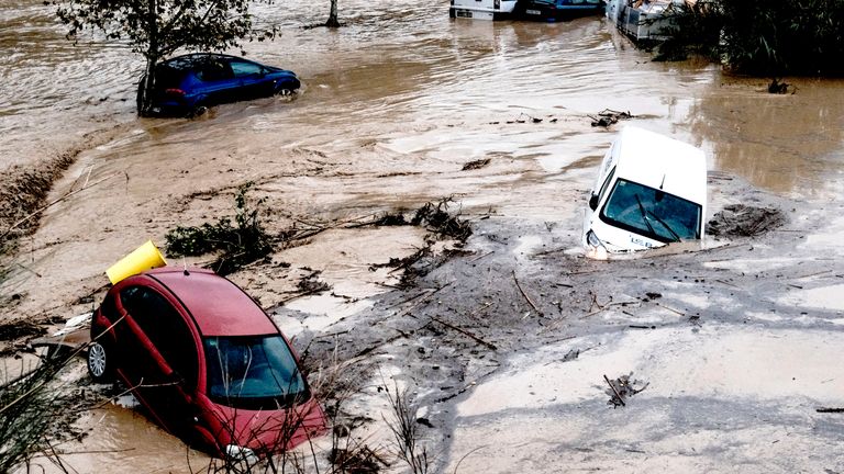 Cars are being swept away by the water, after floods preceded by heavy rains caused the river to overflow its banks in the town of Alora, Malaga, Tuesday, Oct. 29, 2024. (AP Photo/Gregorio Marrero)