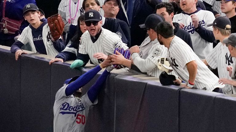 Overzealous fans grapple with Mookie Betts for a ball in Game 4 of the World Series.
Pic: AP