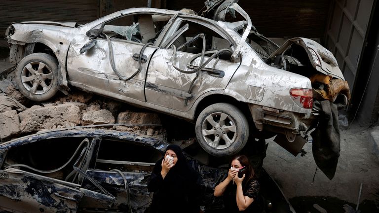 Women stand next to damaged vehicles at the site of an Israeli air strike, amid ongoing hostilities between Hezbollah and Israeli forces, in Beirut, Lebanon, October 11, 2024. REUTERS/Louisa Gouliamaki TPX IMAGES OF THE DAY