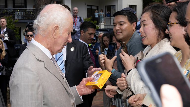 Koning Charles III kijkt naar een pakje Tunnock's Teacakes terwijl hij tot het publiek spreekt na een zondagse kerkdienst in de St Thomas' Anglican Church in het noorden van Sydney op de eerste dag van hun bezoek aan Australië en Samoa. Datum foto: zondag 20 oktober 2024.