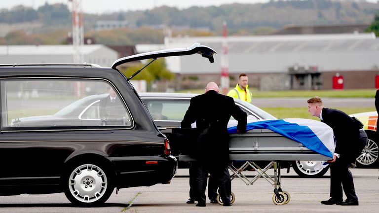 The coffin of former first minister of Scotland Alex Salmond, draped in a Saltire, is loaded onto a hearse
Pic: PA