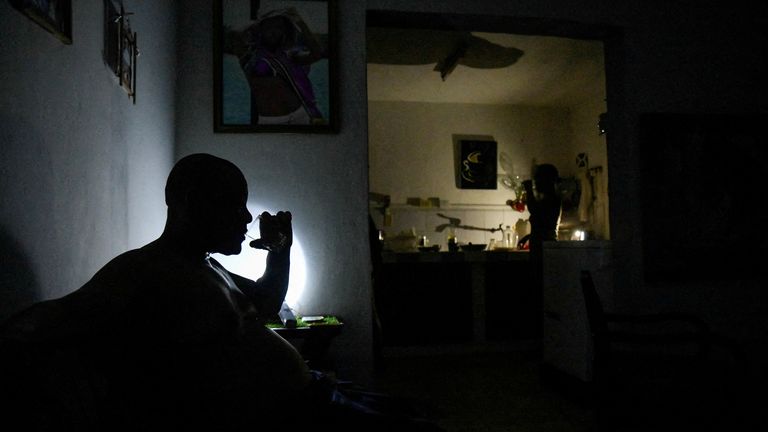 FILE PHOTO: A man drinks water at his home during a power outage caused by breakdowns forcing six plants to go off-line on the grid, according to the state run power company, in Matanzas, Cuba August 22, 2024. REUTERS/Norlys Perez/File Photo