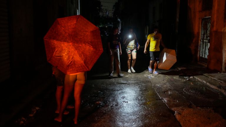 Locals use a torch to light their way on Saturday. Pic: AP