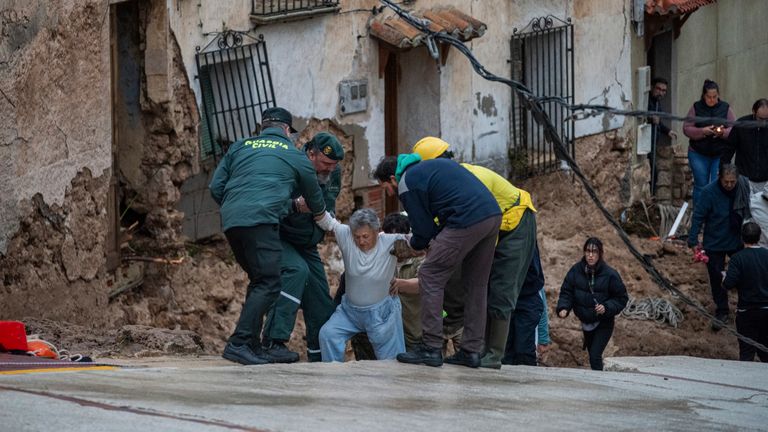 Emergency workers help an elderly lady in Letur. 
Pic: Europa Press via AP