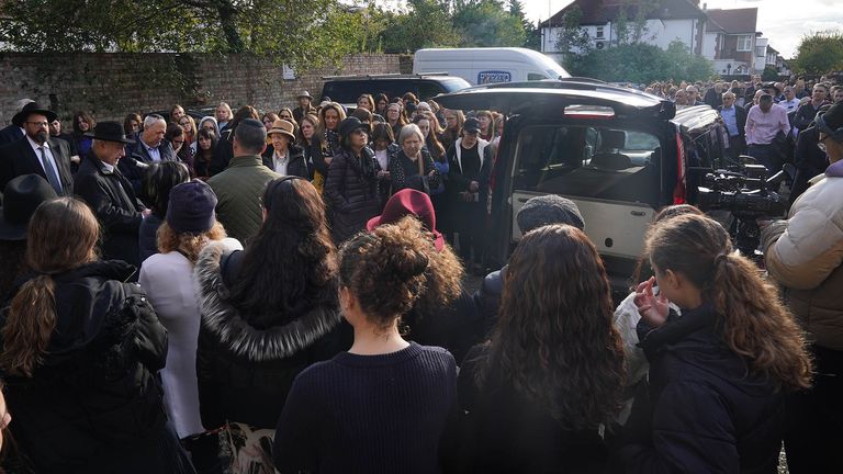 Mourners gather around the funeral car following a service for Ms Ebert at Windsor Court. Pic: PA