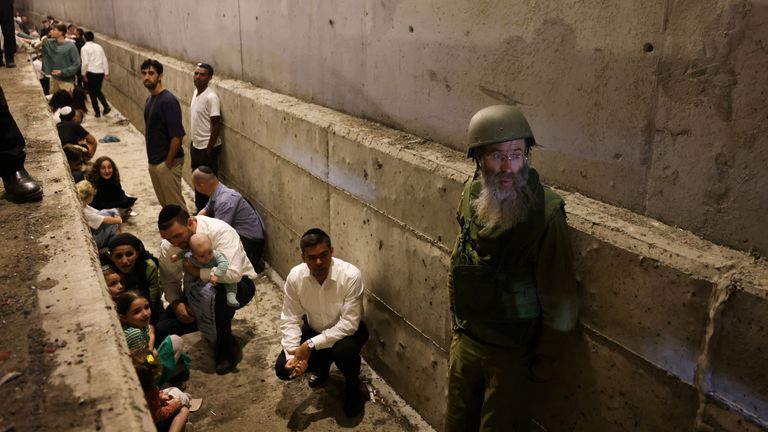 People take shelter during an air raid siren, amid cross-border hostilities between Hezbollah and Israel, in central Israel