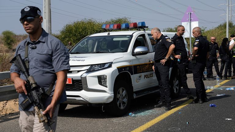 Israeli security forces examine the scene of a shooting attack where they said a police officer was killed and several others were wounded near Yavne, Israel, Tuesday, Oct. 15, 2024. (AP Photo/Tsafrir Abayov)