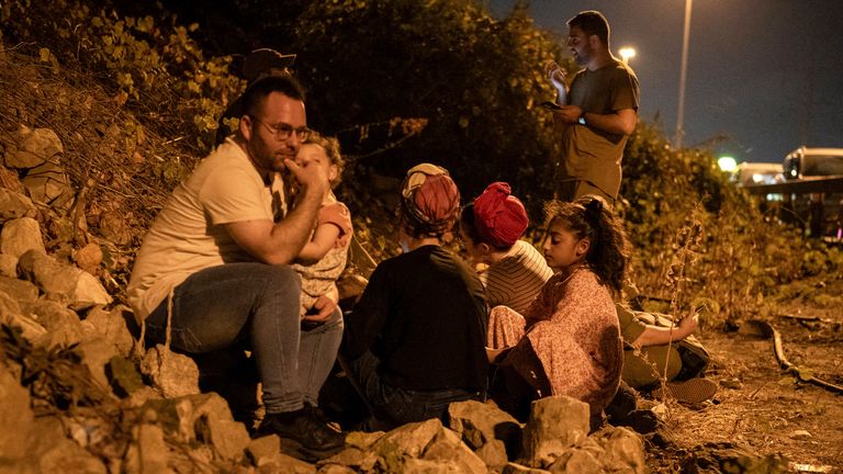 01 October 2024, Israel, Tel Aviv: People take cover on a road side in Tel Aviv, during a warning of incoming missiles launched from Iran. Photo by: Ilia Yefimovich/picture-alliance/dpa/AP Images