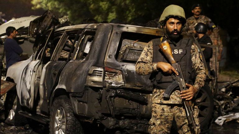 Un miembro de la Fuerza de Seguridad Aeroportuaria de la ASF está de guardia cerca de los restos de vehículos después de una explosión cerca del Aeropuerto Internacional Jinnah en Karachi, Pakistán, el 6 de octubre de 2024. REUTERS/Shakil Adil