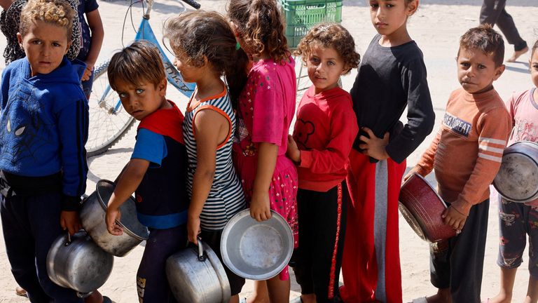 Palestinian children queue to receive food cooked by a charity kitchen in Khan Younis. Pic: Reuters
