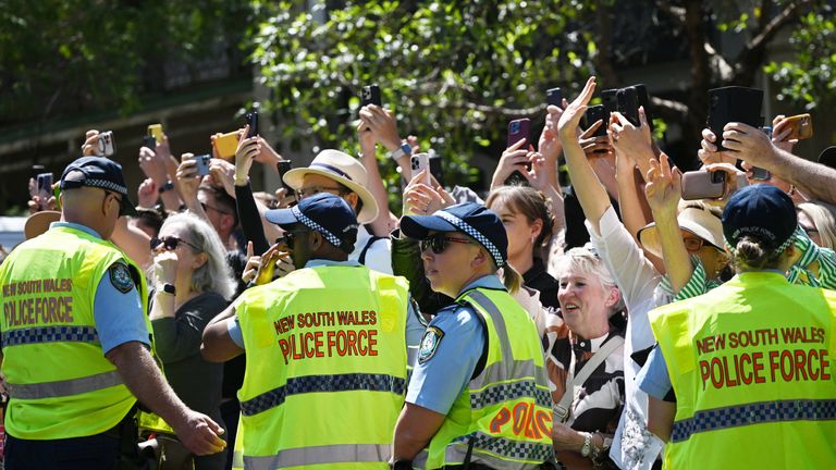 The crowd lift their phones to capture a glimpse of the King. Pic: PA