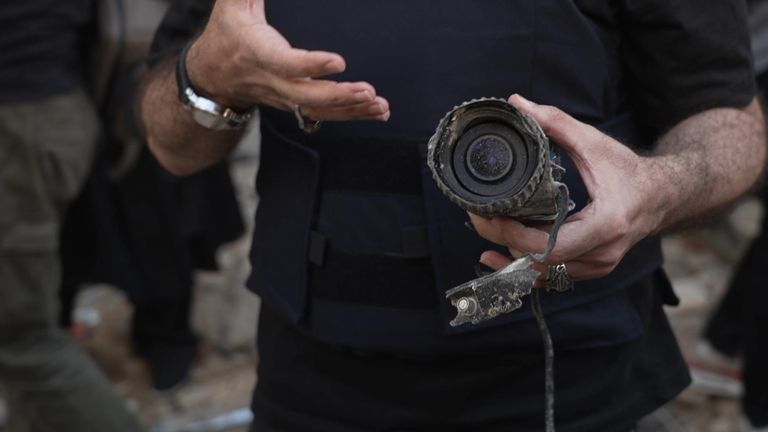 A Hezbollah-affiliated reporter holds a mangled-looking camera lens