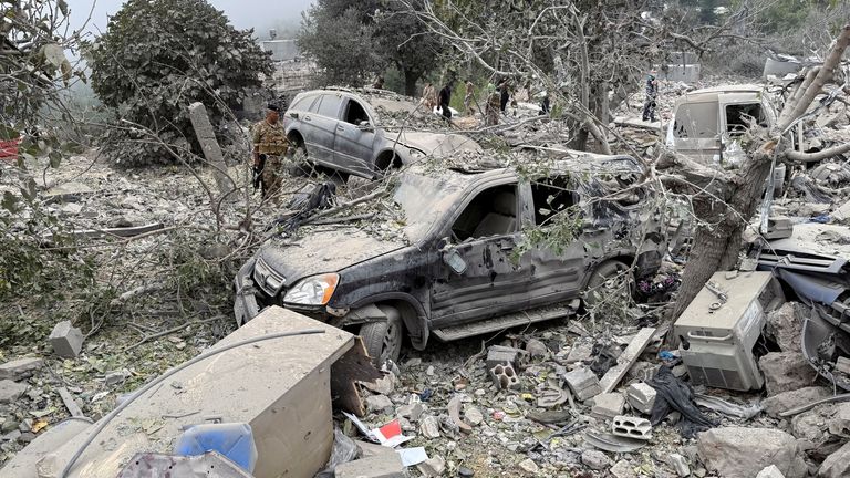 Lebanese army soldier stands near destroyed vehicles at a site damaged by an Israeli air strike in the Christian-majority region of Aitou in north Lebanon, the Lebanese health ministry said, October 14, 2024