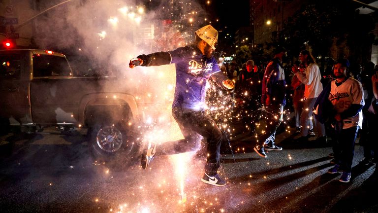 A Dodgers fan celebrates on the street after the Los Angeles Dodgers' victory over the New York Yankees to win the World Series in Los Angeles, California, U.S., October 30, 2024. REUTERS/Daniel Cole     TPX IMAGES OF THE DAY     