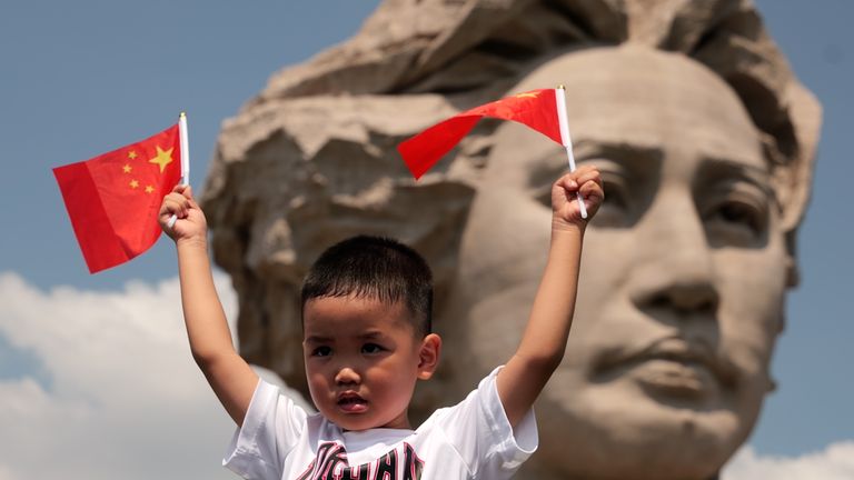 Young boy celebrating China’s National Day at a statue of young Mao Zedong in his home province of Hunan