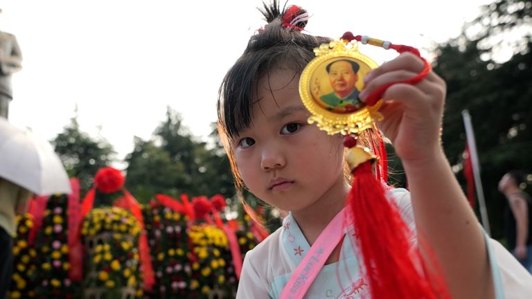 Young girl celebrating China’s National Day by a statue of Mao Zedong at the site of his childhood home in Shaoshan Village, Hunan province