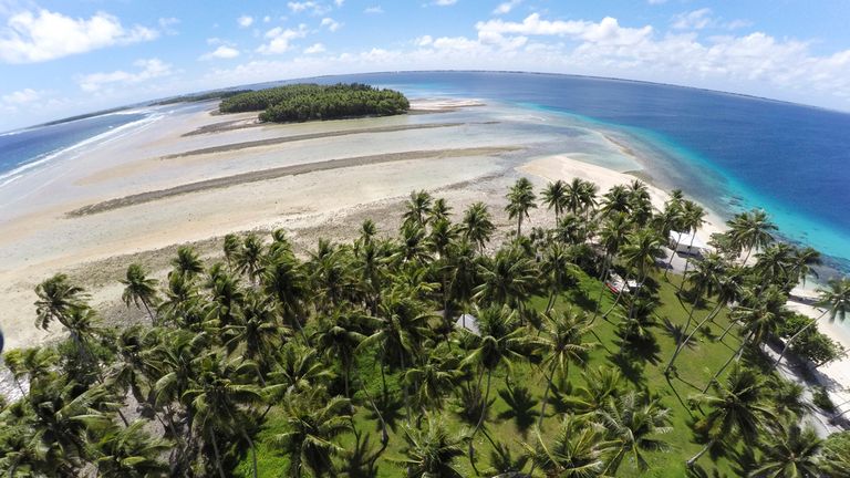 FILE - A section of land between trees is washed away due to rising seas on Nov. 6, 2015, in Majuro Atoll, Marshall Islands. (AP Photo/Rob Griffith, File)