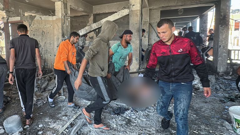 People carry the dead body of a person killed in the latest attack.
Pic: Reuters