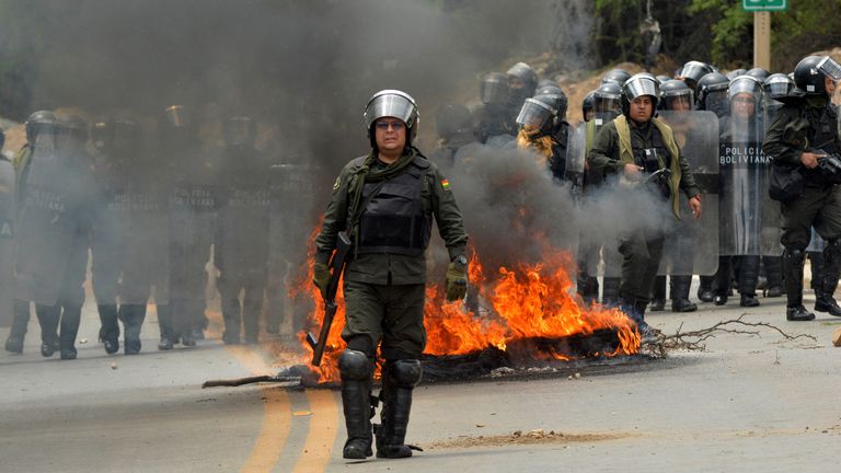 Riot police clash with supporters of former Bolivian President Evo Morales during a roadblock to pressure against him being prosecuted over allegations of minor abuse, near Cochabamba, Bolivia, Friday, Oct. 25, 2024. (AP Photo/Daniel Cartagena)