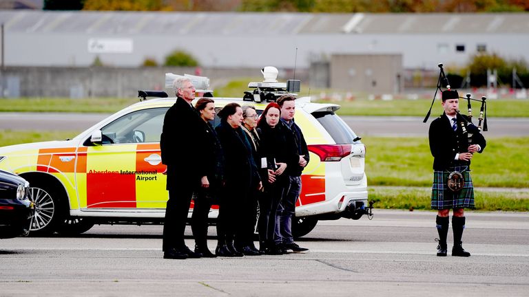 Members of the family and acting Alba leader Kenny MacAskill (left)  wait as the coffin is moved 