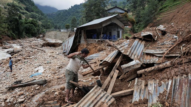 Un hombre retira los escombros de una casa derrumbada después de que las fuertes lluvias provocaran inundaciones y deslizamientos de tierra mortales en la aldea de Bhumidanda, municipio de Panauti, el 1 de octubre de 2024 en Kawre, Nepal. REUTERS/Navesh Chitrakar