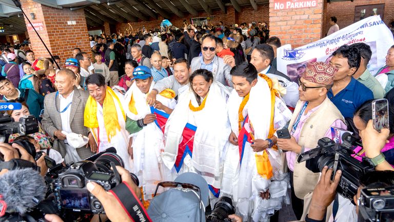 Nima Rinji Sherpa (second from right), the youngest person to scale all the world's 14 highest peaks, along with other climbers arrive at Tribhuvan International Airport in Kathmandu, Nepal, Monday, Oct. 14, 2024. (AP Photo/Niranjan Shrestha)