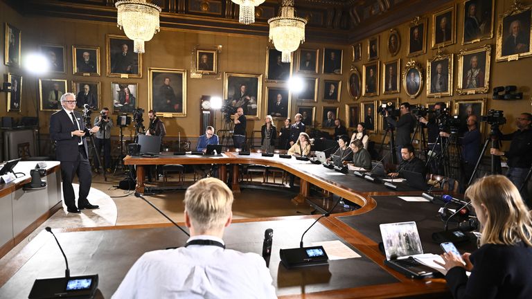 Journalists listen when Jan Teorell of the Nobel assembly announces the Nobel memorial prize in economics winners during a press meeting at the Royal Swedish Academy of Sciences in Stockholm, Sweden, Monday Oct. 14, 2024. (Christine Olsson/TT News Agency via AP)