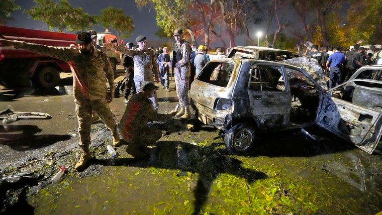 Funcionarios de seguridad examinan autos dañados en el lugar de una explosión que hirió y destruyó vehículos afuera del aeropuerto en Karachi, Pakistán, el lunes 7 de octubre de 2024. (Foto AP/Fareed Khan)