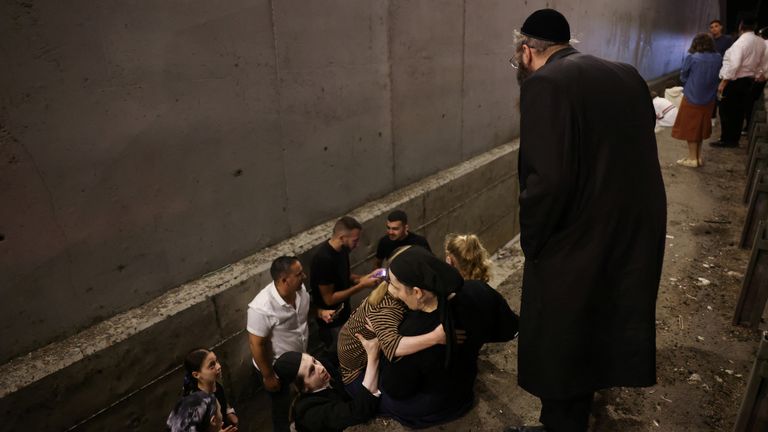 People take shelter during an air raid siren, amid cross-border hostilities between Hezbollah and Israel, in central Israel. Pic: Reuters