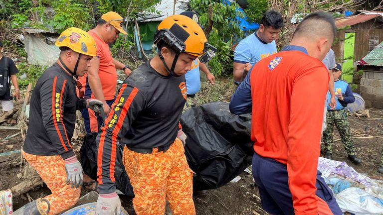 Rescuers carry a body after a landslide triggered by Tropical Storm Trami struck homes in Talisay, Batangas province, Philippines, Saturday, Oct. 26, 2024. (AP Photo/Jim Gomez)