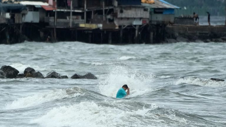 A man swims in the strong waves caused by Tropical Storm Trami in Manila. Pic: AP