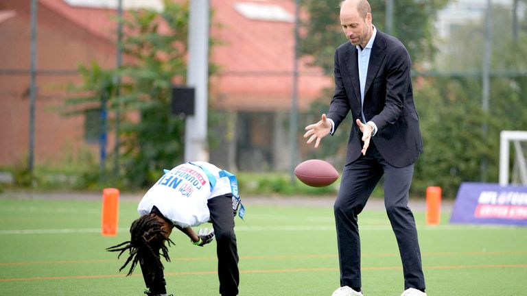 The Prince of Wales catches a football during the community visit.
Pic: Reuters