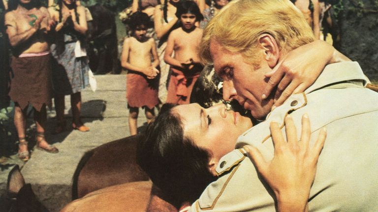 1975: Ron Ely como Doc Savage: El Hombre de Bronce en un apasionado abrazo con Pamela Hensley Foto: Everett/Shutterstock