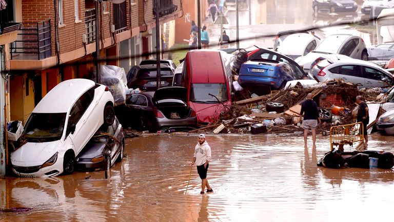 Residents look at cars piled up after being swept away by floods in Valencia, Spain. Pic: AP 