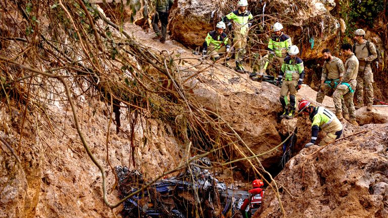 Emergency personnel work in a flooded area after heavy rains caused flooding in Letur, Spain.
Pic: Reuters