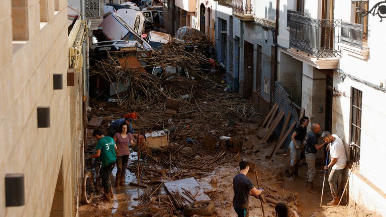 Les gens travaillent pour dégager une rue couverte de boue avec des voitures empilées à la suite de pluies torrentielles qui ont provoqué des inondations, à Paiporta, Espagne, le 31 octobre 2024. REUTERS/Eva Manez