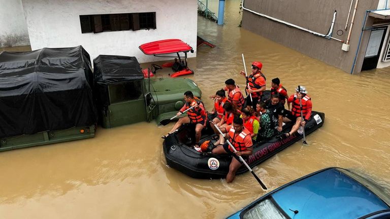 Philippine Coast Guard personnel evacuate residents in Camarines Sur. Pic: Reuters