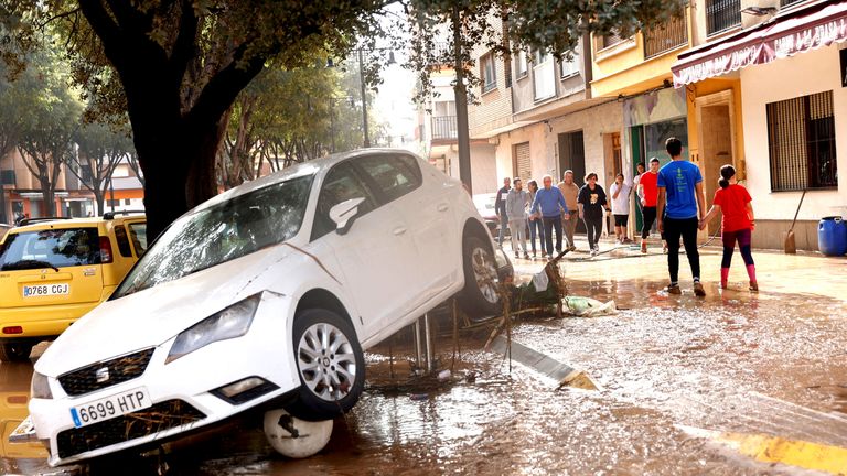 People walk along a mud-covered street after torrential rains caused flooding in La Alcudia.
Pic: Reuters