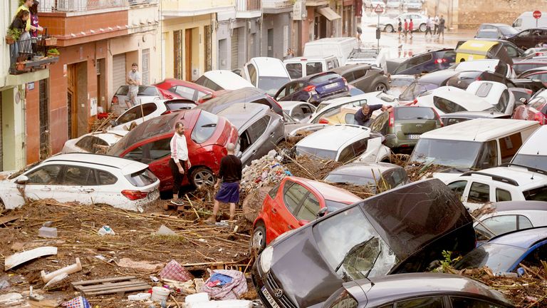 Residents look at cars piled up after being swept away by floods in Valencia.
Pic: AP