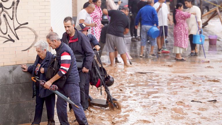 People walk through flooded streets in Valencia.
Pic: AP