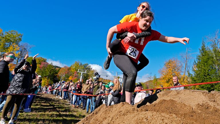 Molly Sunburn carries Megan Crowley over a sand pile during the North American Wife Carrying Championship. Pic: AP Photo/Robert F Bukaty