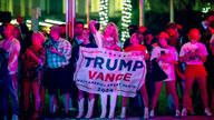 People stand on a street to try to view former President Donald Trump's motorcade ahead of his arrival for an election watch party at the Palm Beach County Convention Center in West Palm Beach, Fla., Nov. 5, 2024. (Francis Chung/POLITICO via AP Images)