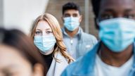 Authentic shot of multiracial people in the city wearing face mask and walking on the pavement commuting to work - Lifestyle and health issues concepts