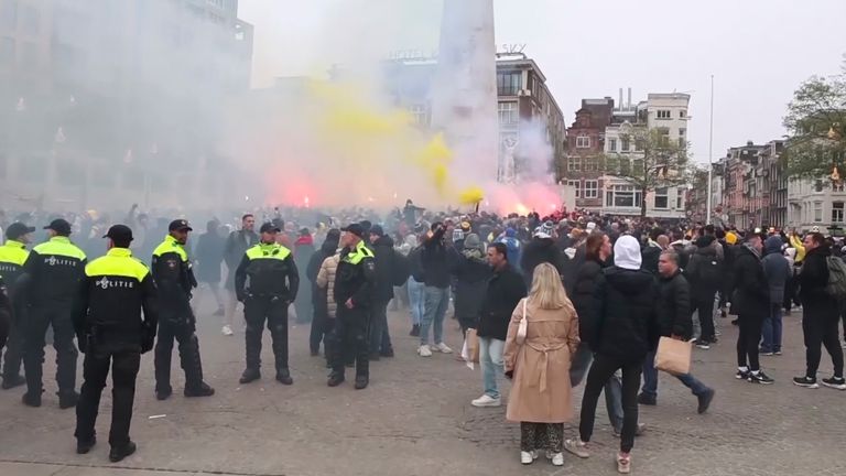 In this image taken from video, police stand guard as Maccabi Tel Aviv supporters light flares at the Dam square, in Amsterdam, the Netherlands, Thursday, Nov. 7, 2024. (AP Photo InterVision)