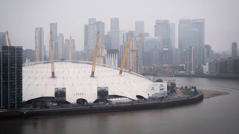 Widok na arenę O2 na półwyspie Greenwich w południowo-wschodnim Londynie, gdy niebo staje się szare w wyniku wysokiego ciśnienia nad Wielką Brytanią zatrzymującego wilgoć w pobliżu powierzchni Ziemi, tworząc uporczywe chmury lub, mówiąc w żargonie pogodowym, „mrok antycykloniczny” '. Wysokie ciśnienie powoduje niewielki lub żaden wiatr, który w przeciwnym razie poruszałby chmurę i ją rozbijał. Data zdjęcia: piątek 8 listopada 2024 r.